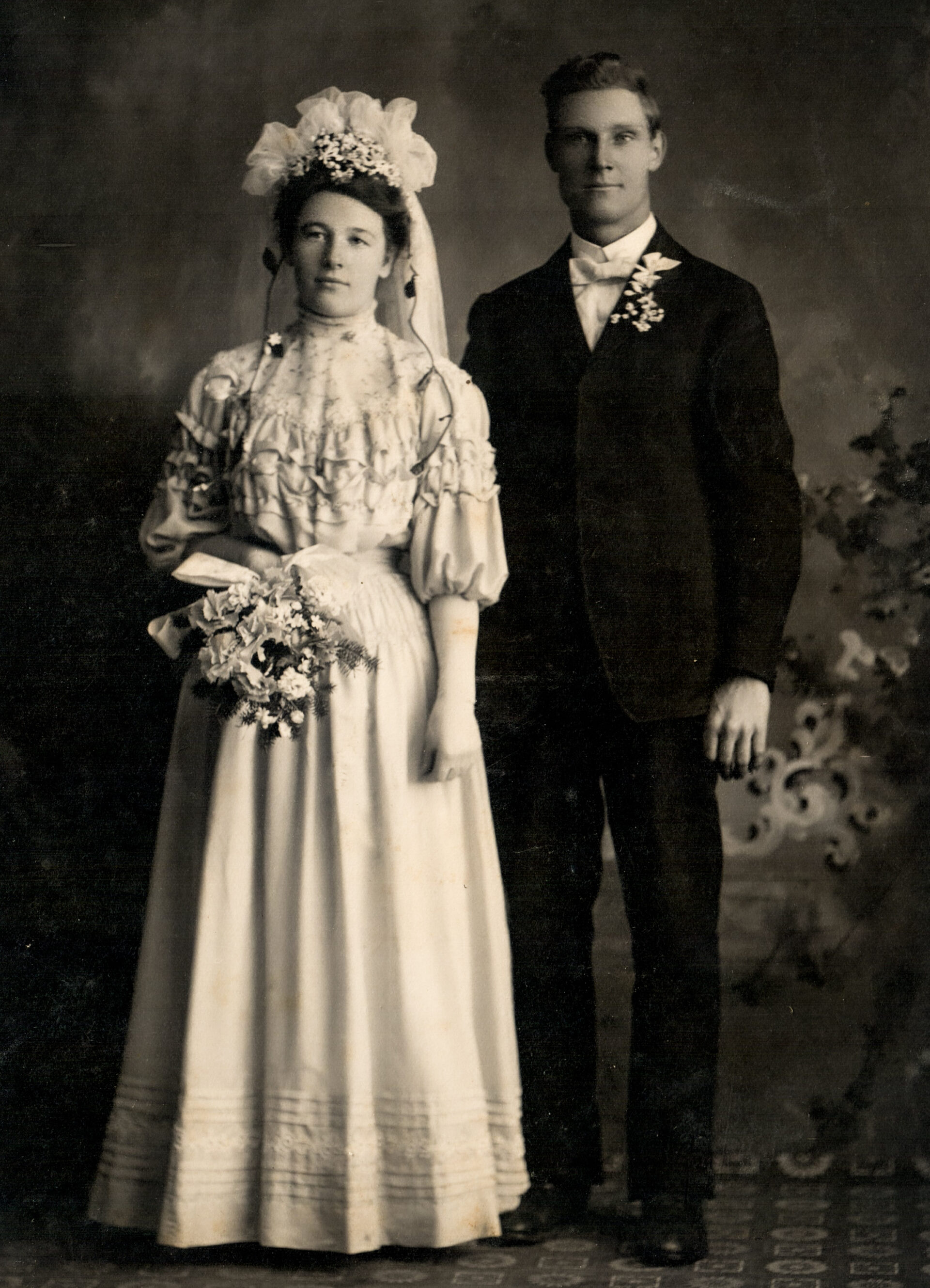 edwardian-wedding-portrait-of-a-bride-in-ruffled-dress-and-groom-in-formal-suit