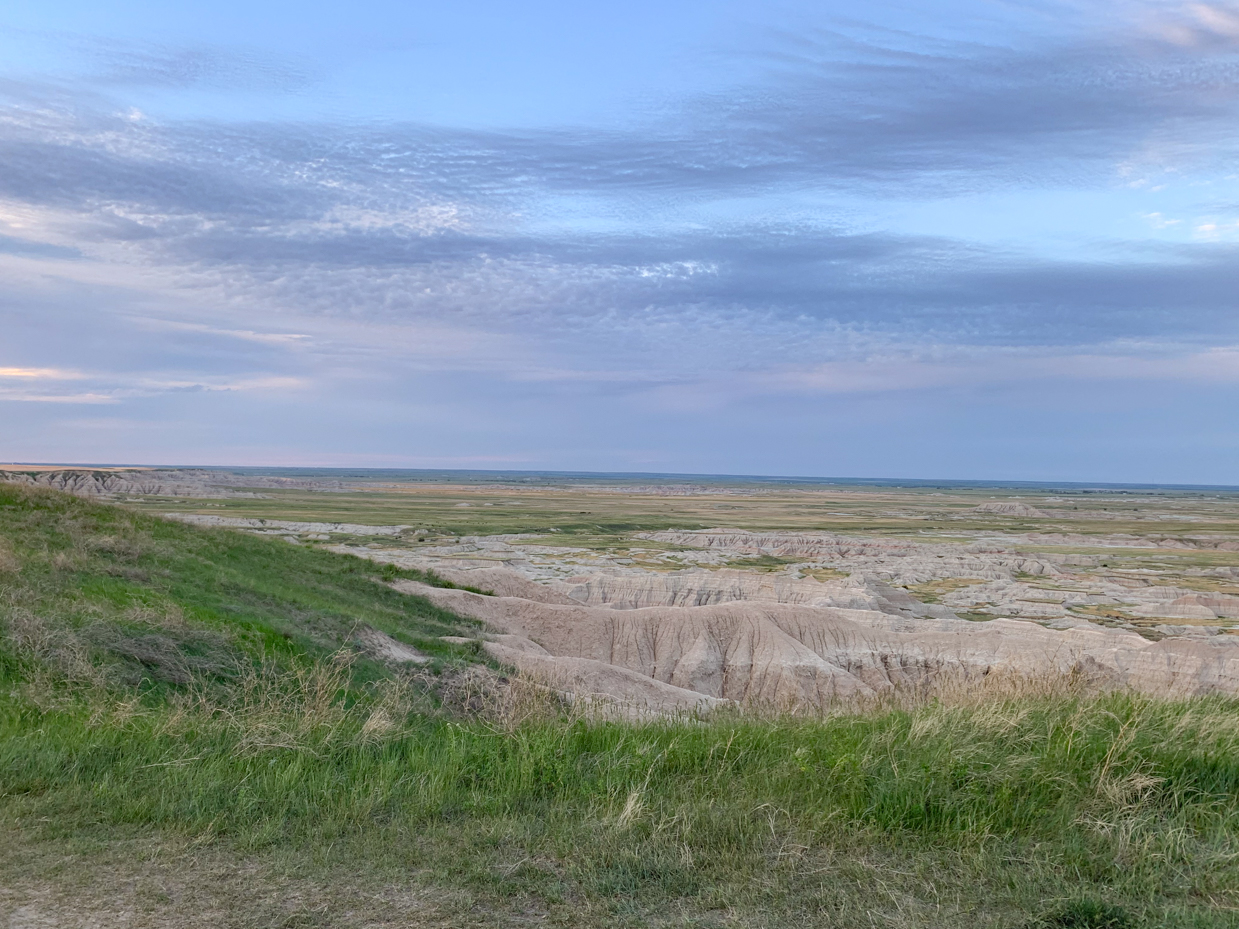 expansive-badlands-landscape-under-a-vast-blue-sky-majestic-natural-scenery