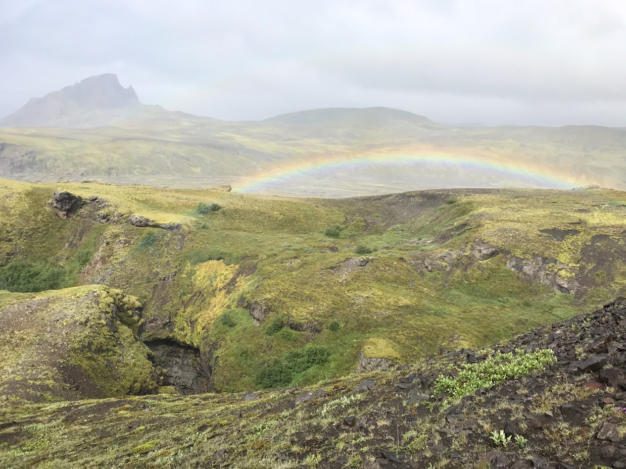 icelandic-hillside-with-vibrant-rainbow-arching-over-lush-landscape