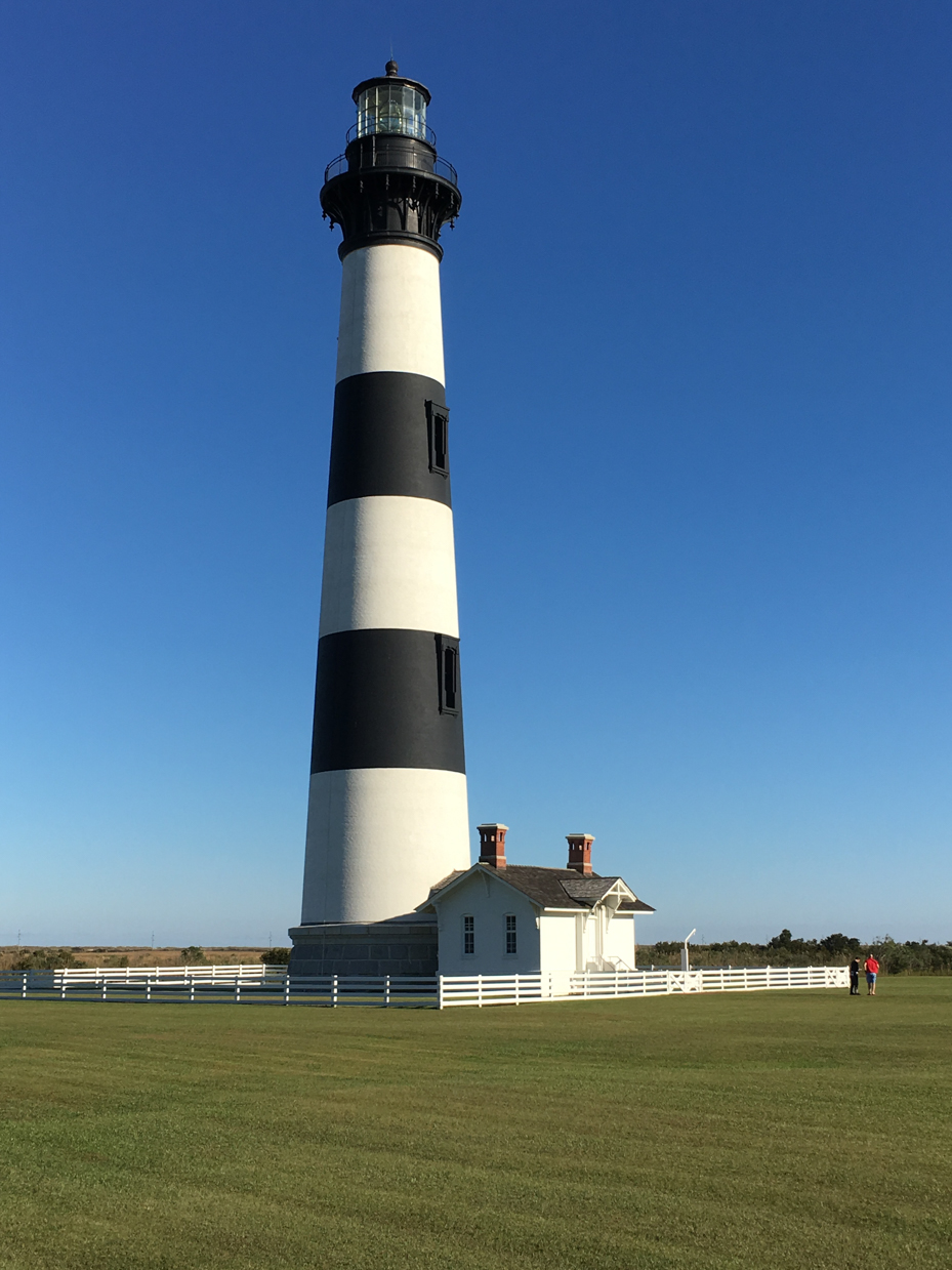 iconic-black-and-white-lighthouse-standing-tall-under-a-clear-blue-sky-coastal-landmark-photography