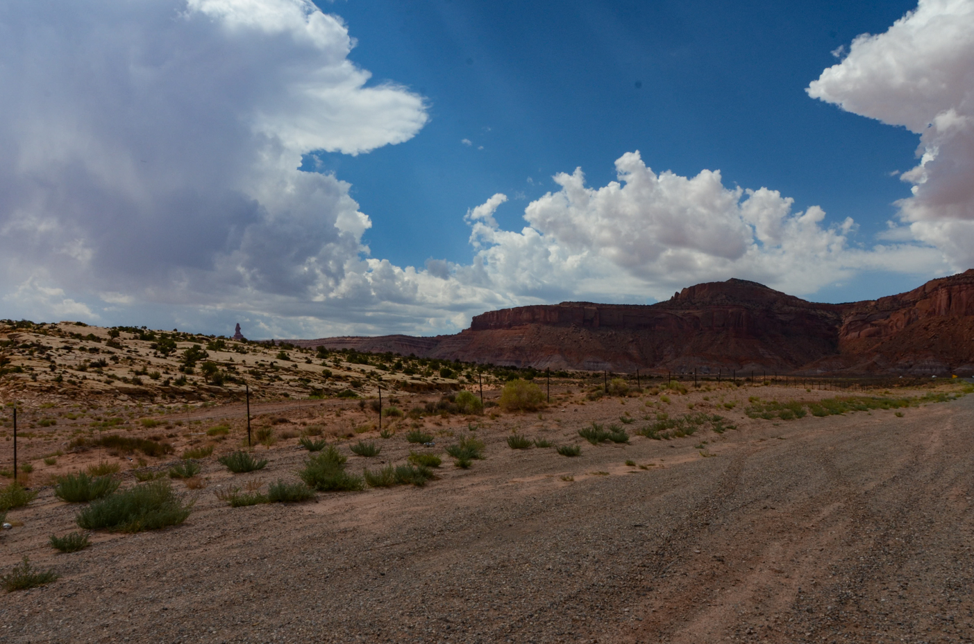 majestic-red-rock-mesas-overlooking-arid-desert-plains-under-billowing-cumulus-clouds