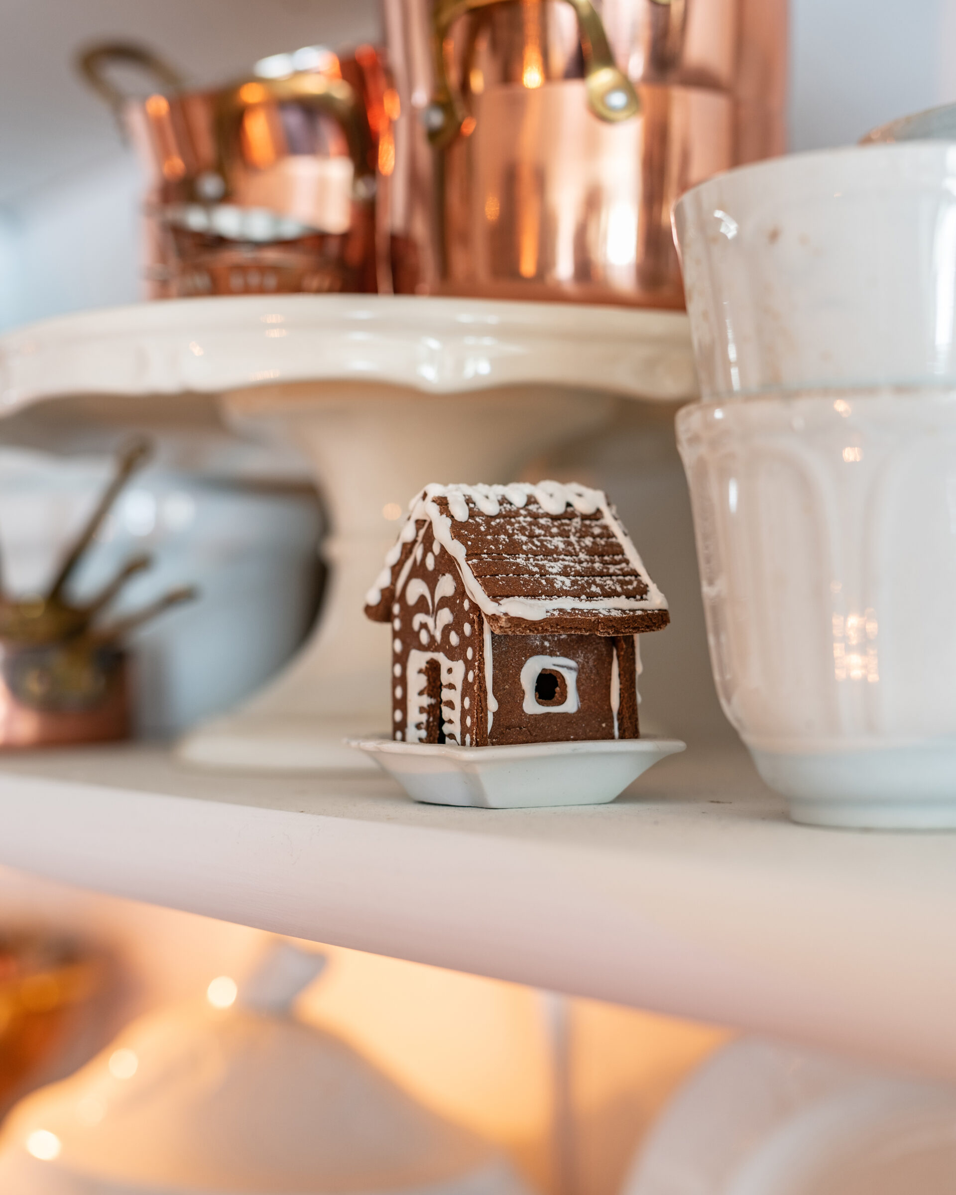 mini-gingerbread-house-on-shelf-with-copper-pots-and-vintage-kitchen-decor