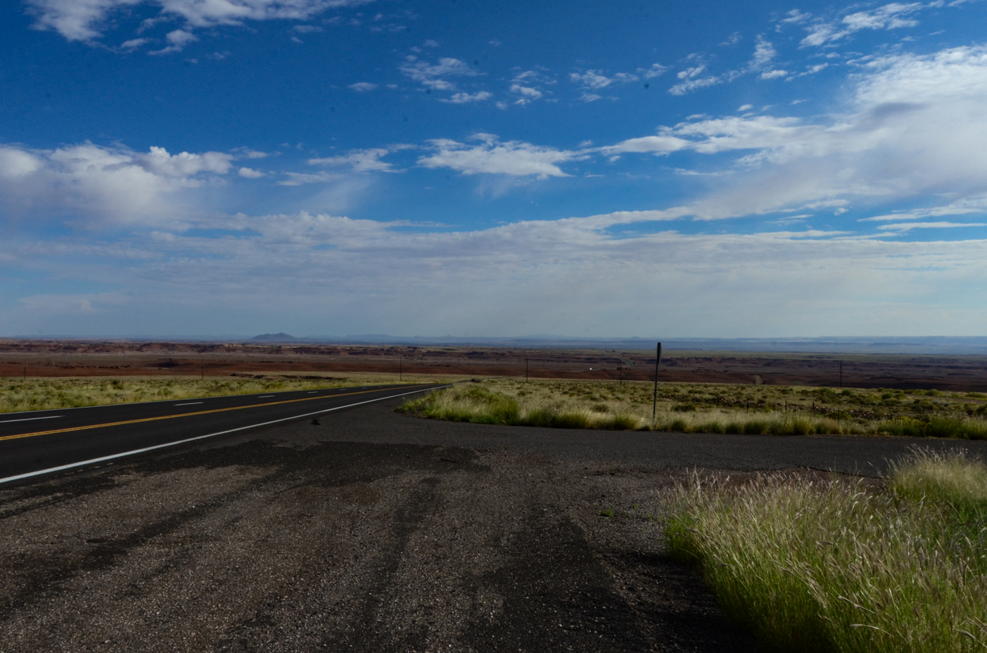 open-road-in-vast-desert-landscape-under-blue-sky-scenic-horizon-view-royalty-free-reference-photo