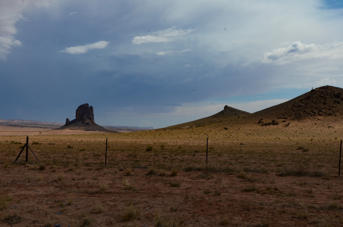 rugged-butte-and-desert-expanse-under-dramatic-sky-in-monument-valley