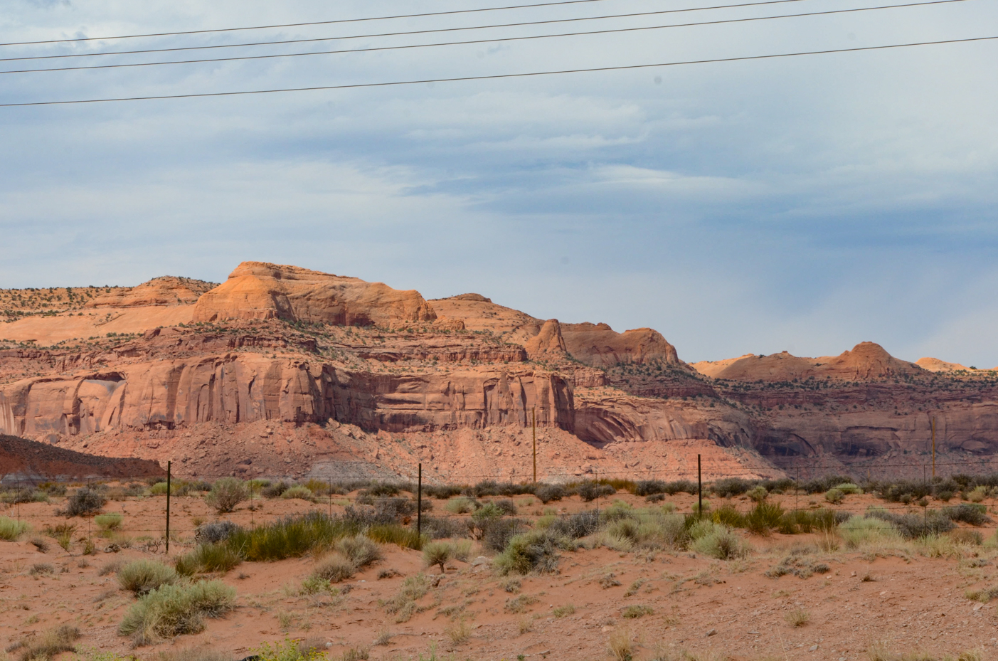 rugged-sandstone-cliffs-dominating-arid-desert-landscape-under-vast-western-sky