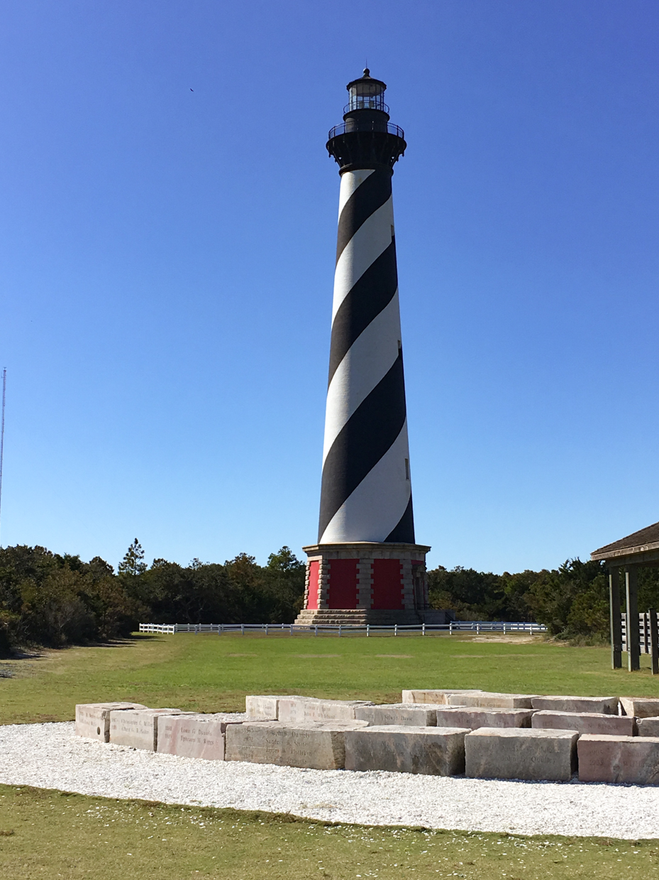 spiral-striped-lighthouse-towering-over-coastal-landscape-iconic-seaside-landmark