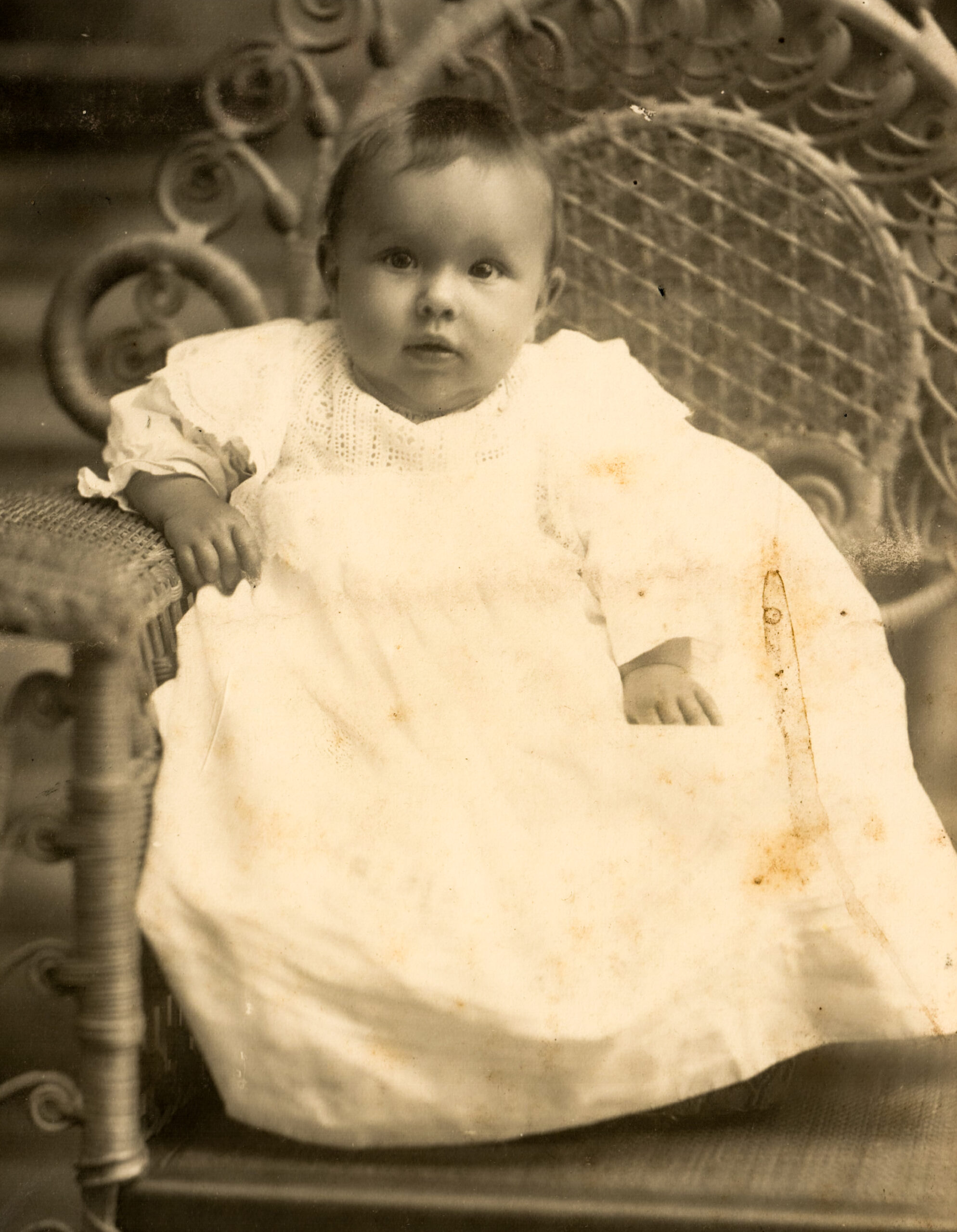 Vintage Portrait of a Baby in a Long Christening Gown Seated on a Wicker Chair artist reference photo