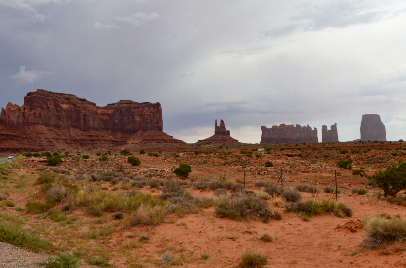 winding-desert-road-towards-iconic-monument-valley-silhouettes-under-stormy-skies