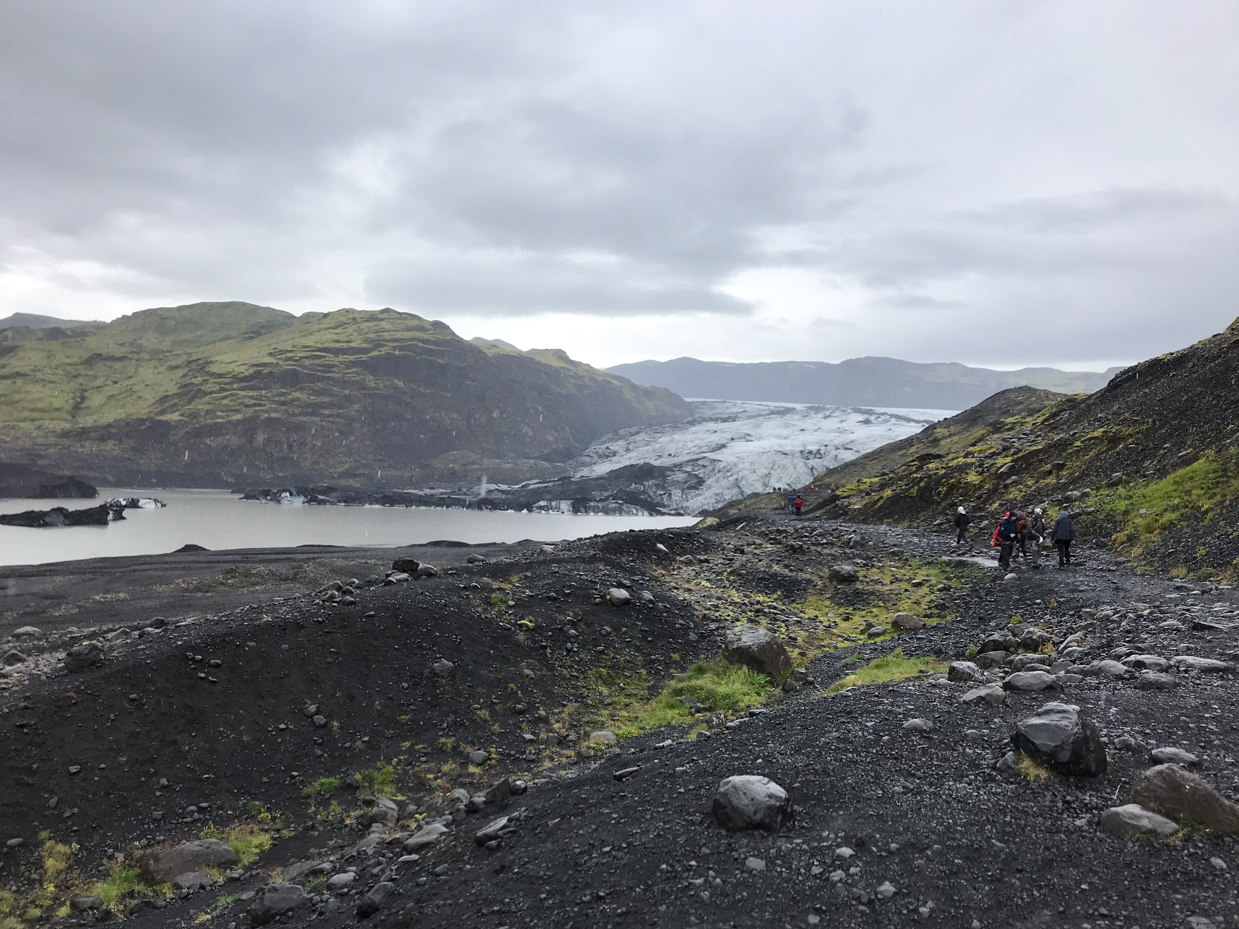 hikers-trekking-toward-a-vast-glacier-and-scenic-lagoon-in-a-rugged-landscape-adventure-in-iceland