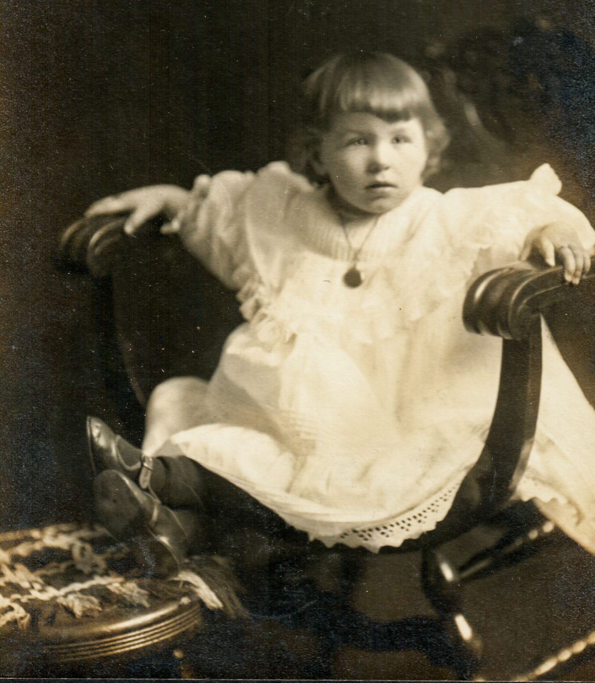 portrait-of-toddler-in-chair-with-dark-background