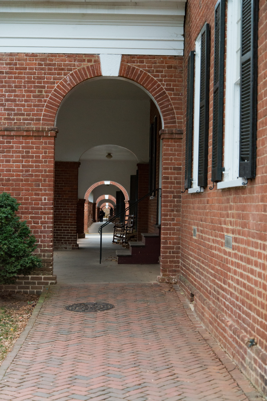 historic-university-archway-with-herringbone-brick-path-and-rocking-chairs-uva-campus-architecture