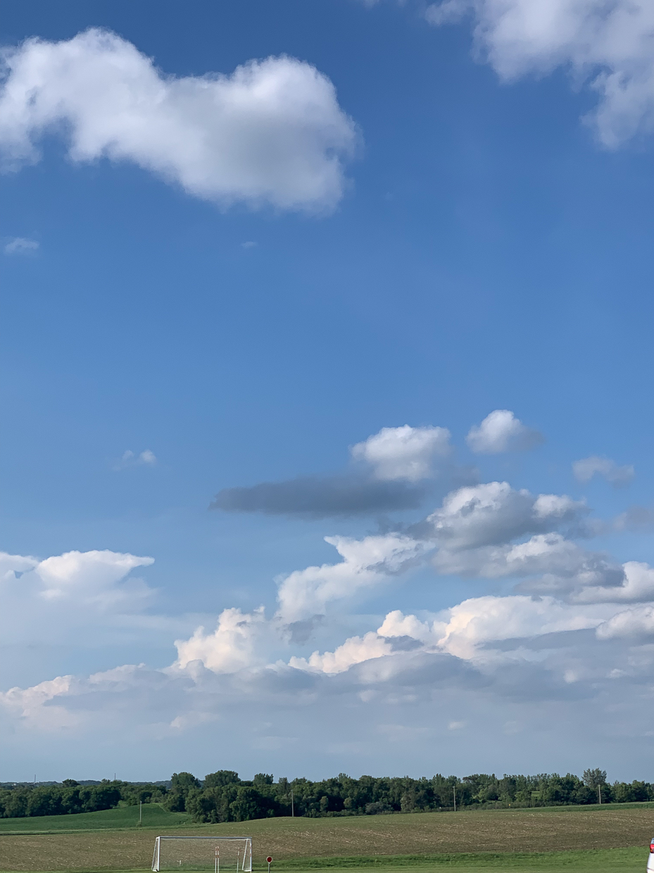 bright-blue-sky-with-fluffy-white-clouds-over-open-fields-peaceful-countryside-scene