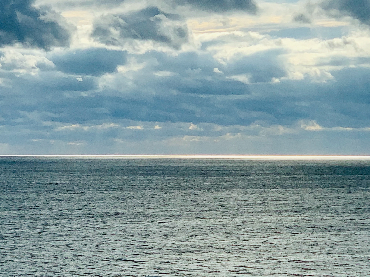 moody-ocean-horizon-with-dramatic-cloudy-sky-and-subtle-sunlight-serene-seascape