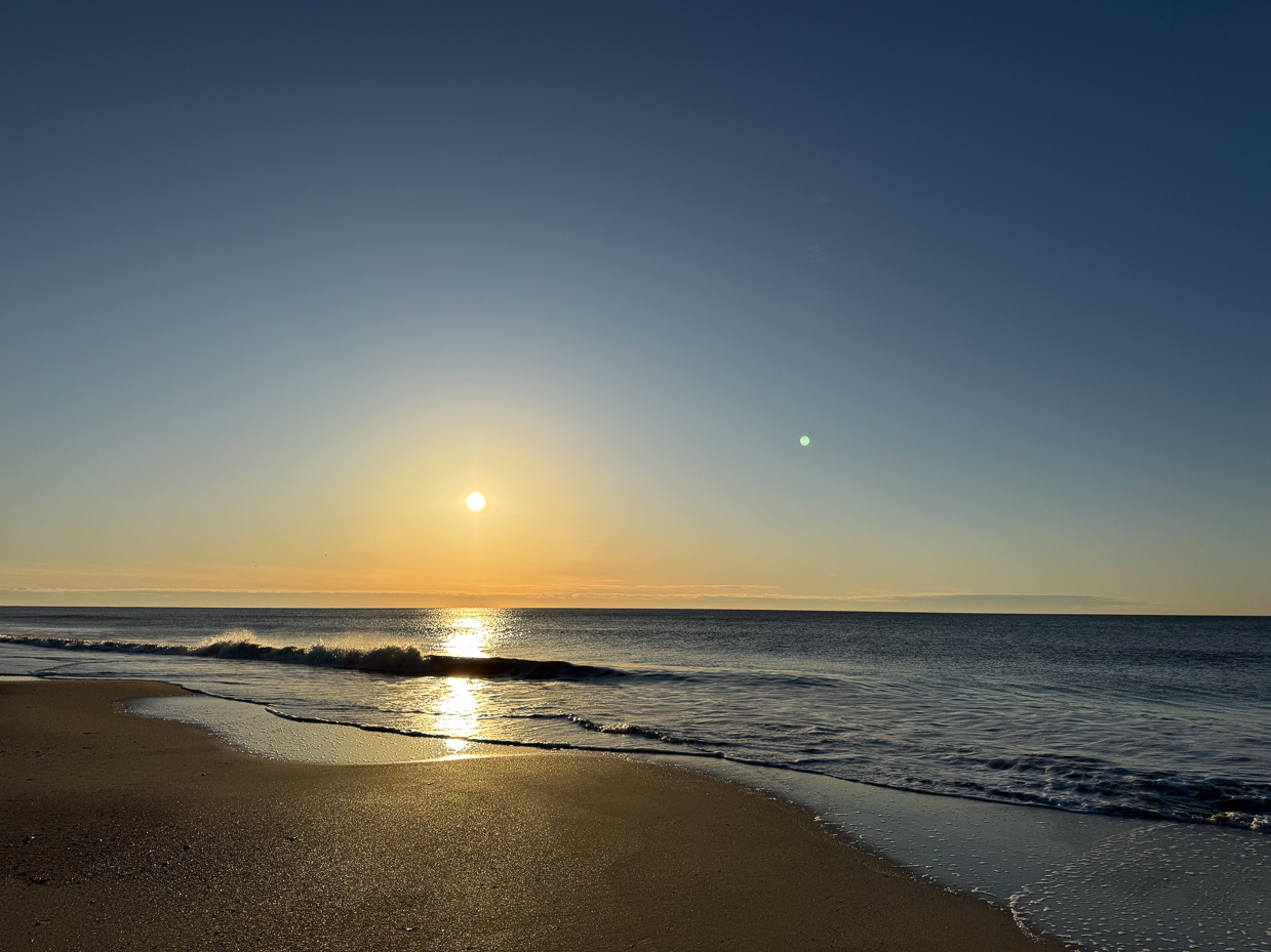 golden-sunrise-over-calm-ocean-waves-on-sandy-beach-horizon