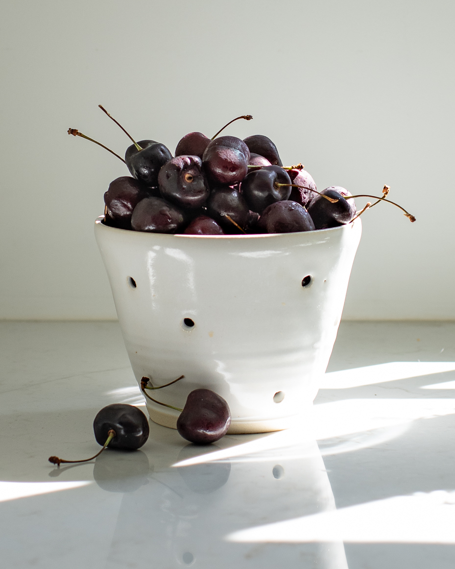 moody-cherries-in-handmade-ceramic-colander-natural-light-still-life