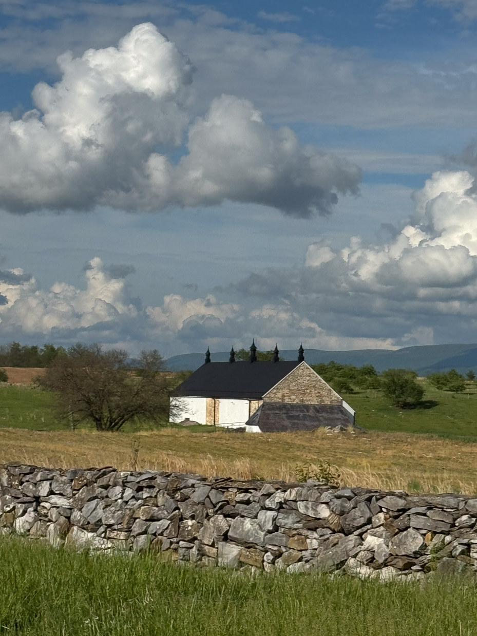 old-stone-barn-and-rolling-cloudscape-behind-field-wall-artist-reference-photo