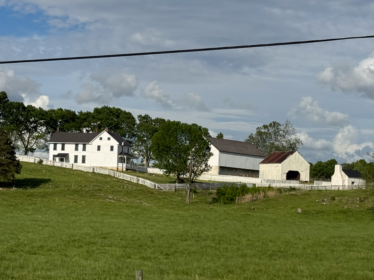 white-farmhouse-and-historic-barns-framed-by-trees-and-fence-artist-reference-photo