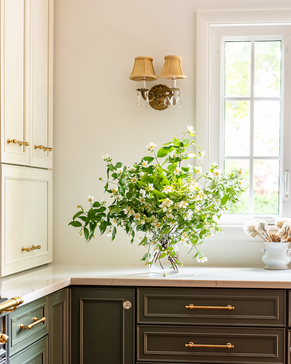 white-jasmine-bouquet-in-glass-vase-on-marble-counter-under-vintage-wall-sconce-in-bright-farmhouse-kitchen-artist-reference-photo