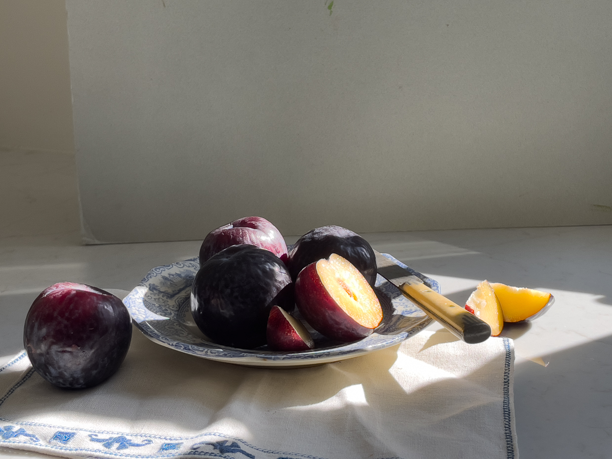moody-plum-still-life-farmhouse-table-natural-light-vintage-kitchen-fruit-photography-rustic-elegance