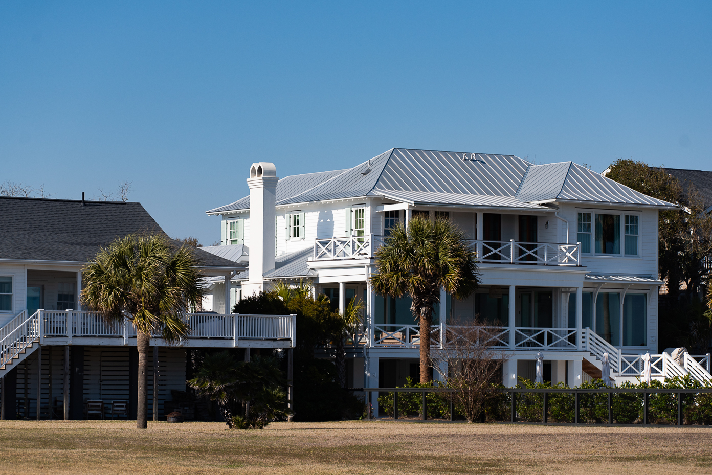 coastal-white-beach-house-with-green-shutters-and-wraparound-balcony