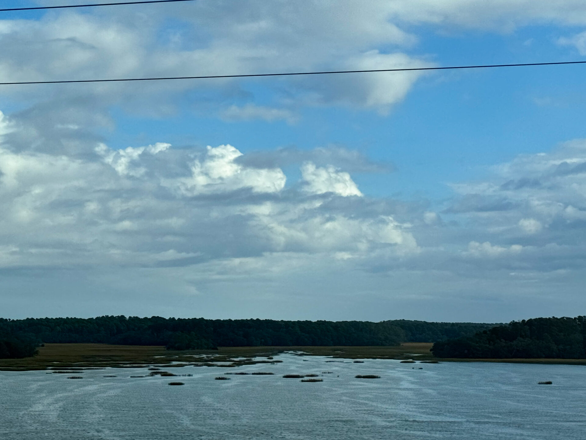 blue-sky-over-winding-marsh-channel-with-tree-line-horizon-artist-reference-photo