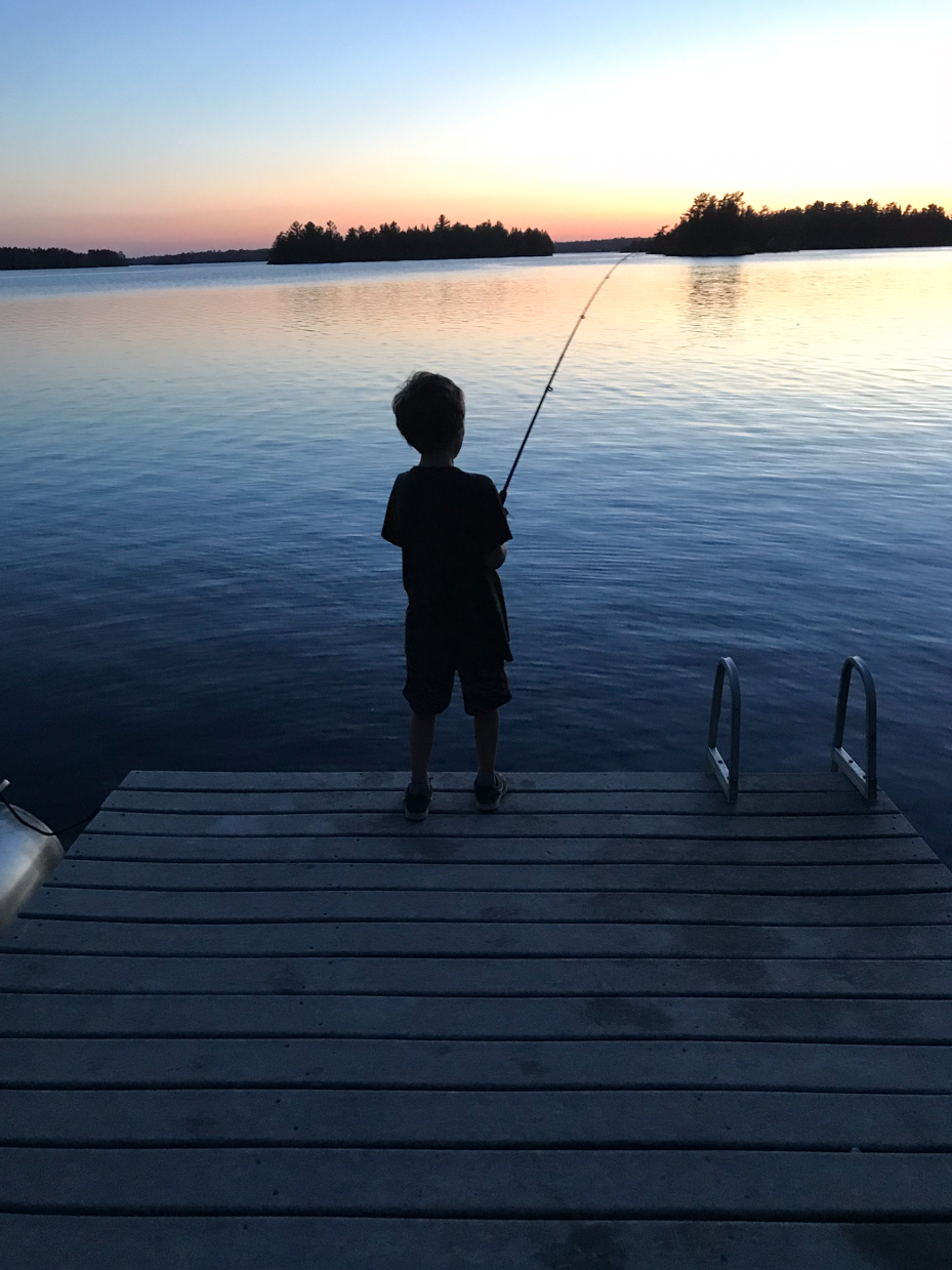 boy fishing at twilight on dock over still lake artist reference photo