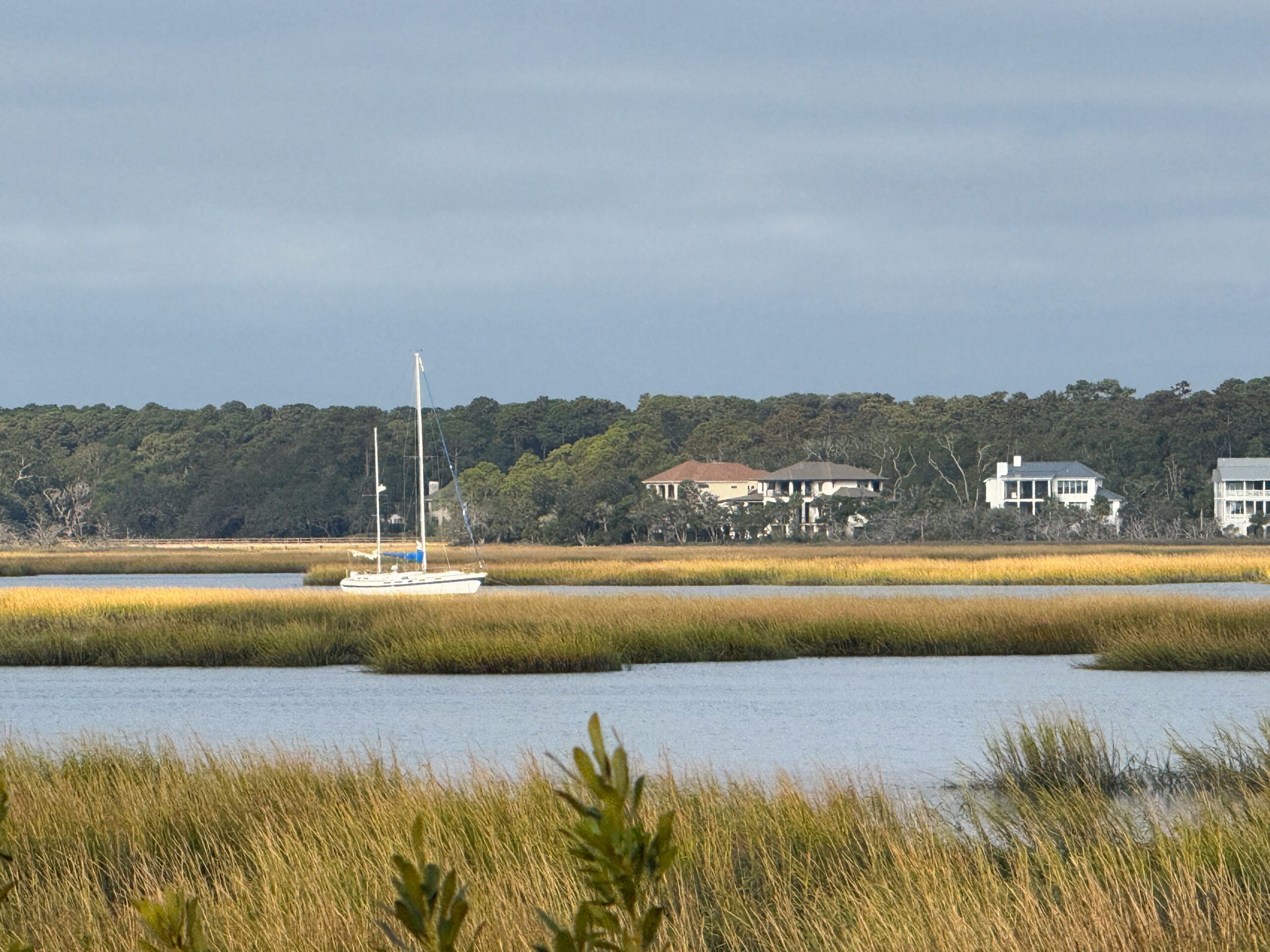 sailboat anchored in marsh inlet with luxury coastal homes artist reference photo
