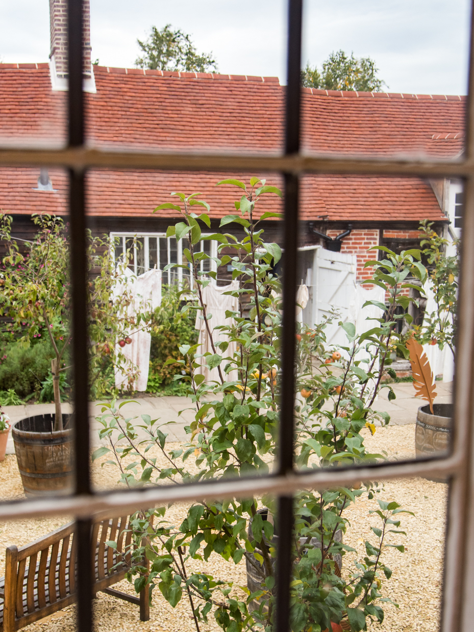 View Through Cottage Window to Garden Courtyard and Red Tile Roof artist reference photo